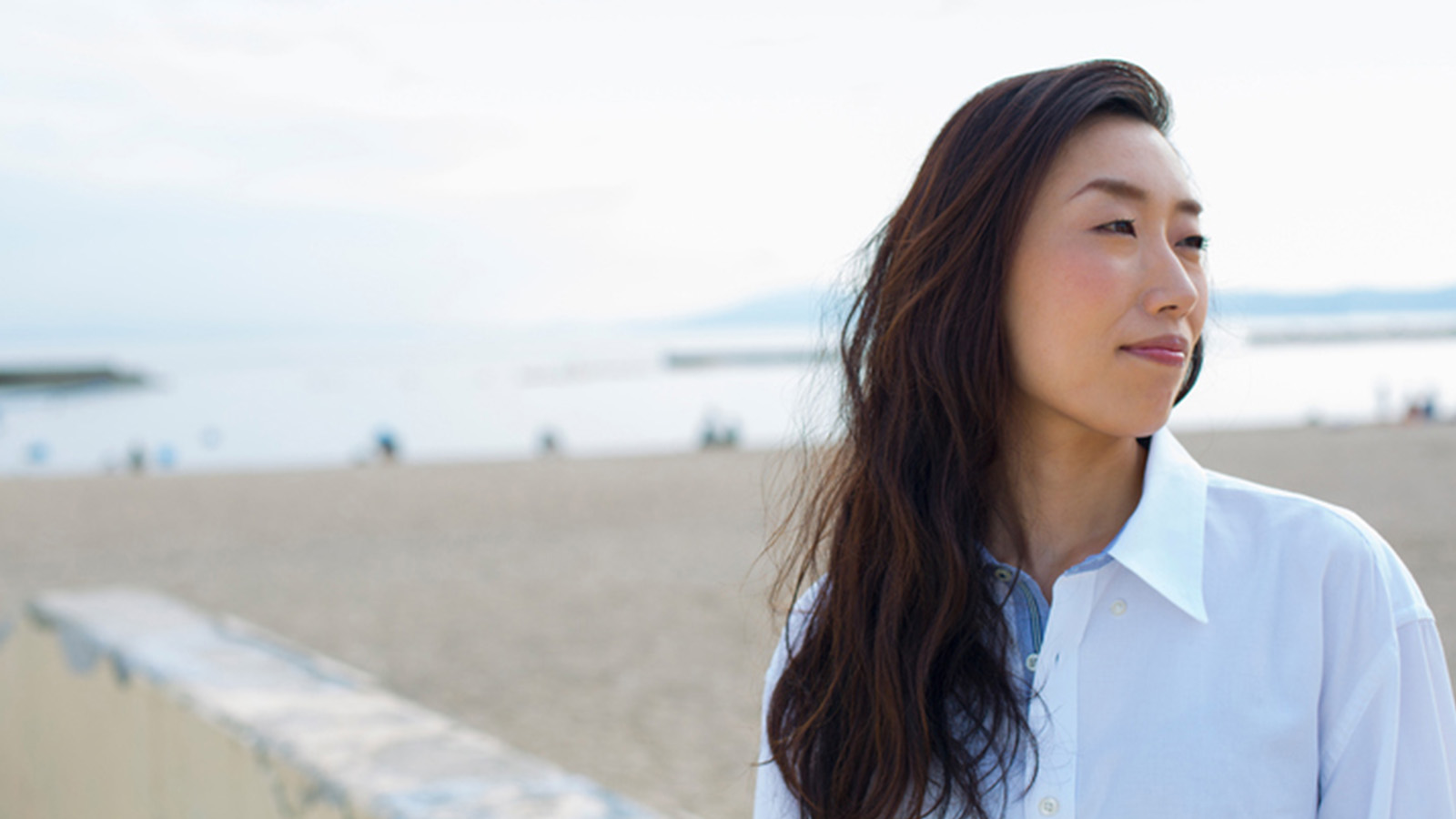 Woman featured in annual report cover looking away on beach