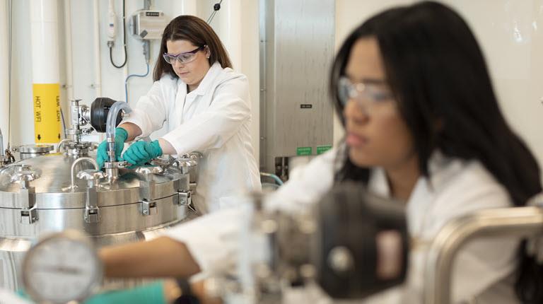 Two women work in biotech manufacturing