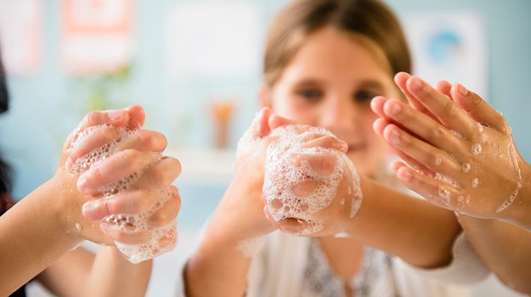 Children holding up soapy hands