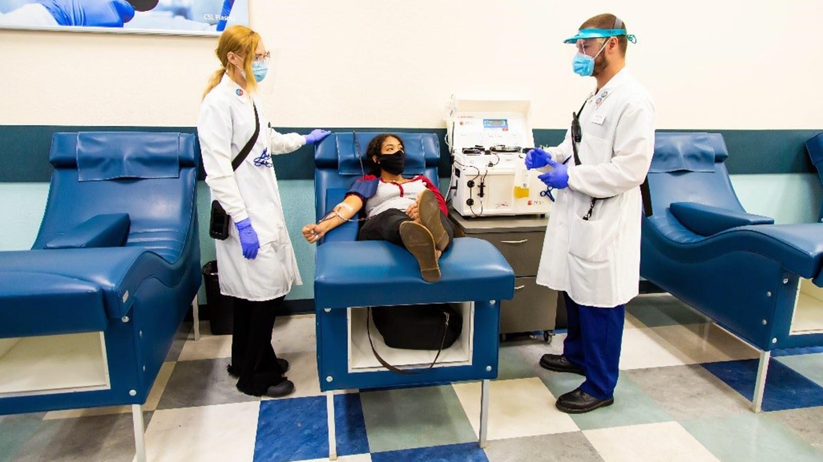 Plasma donor and two CSL Plasma staff members in PPE