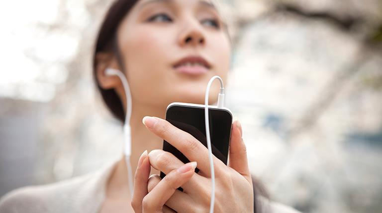 Woman listening to music on smartphone