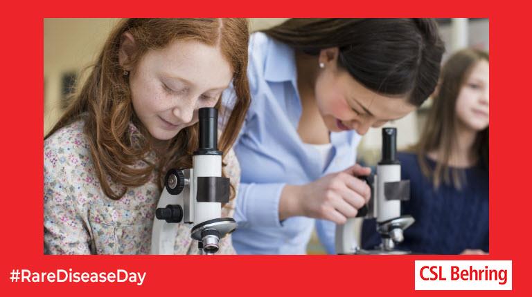 two girls looking into microscopes