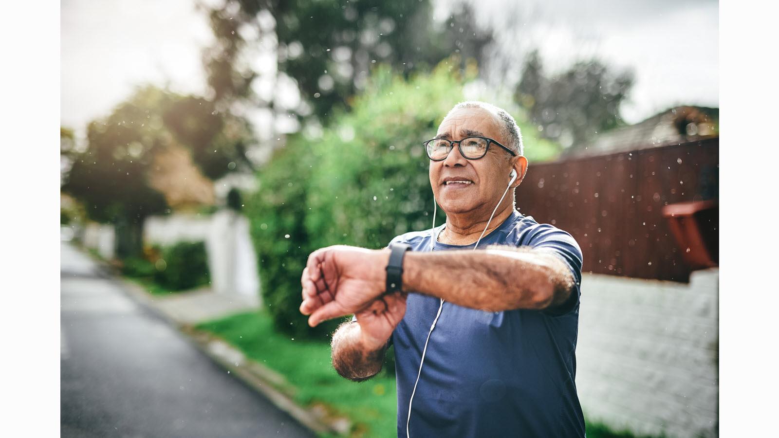 Senior man exercising and wearing ear buds