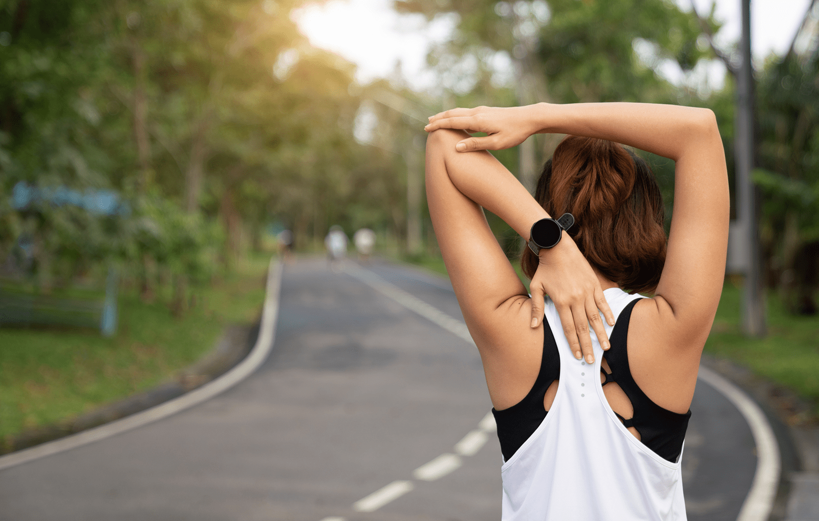 Woman stretching on the side of a road about to exercise