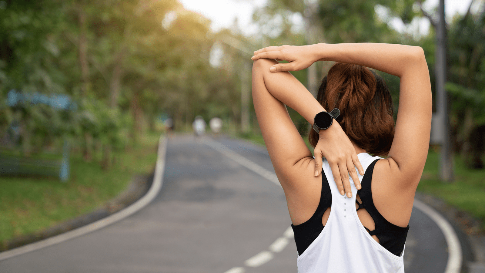 Woman stretching on the side of a road about to exercise