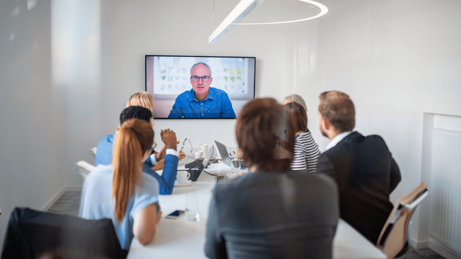 Group of office team members in an office watching a screen