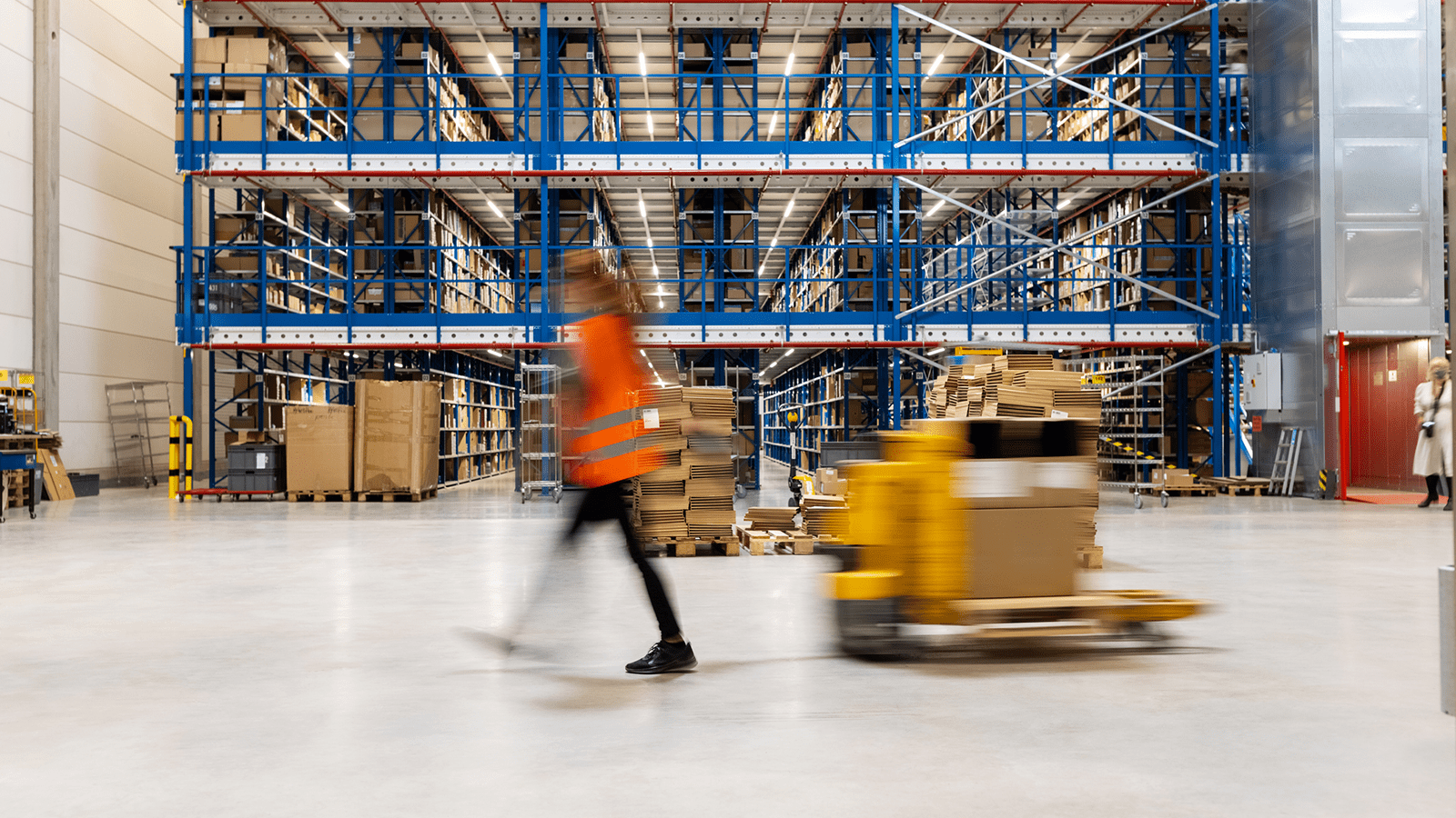 Person using a pallet jack in a warehouse