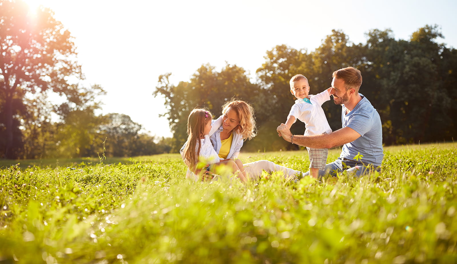 Image of happy family playing in a green park