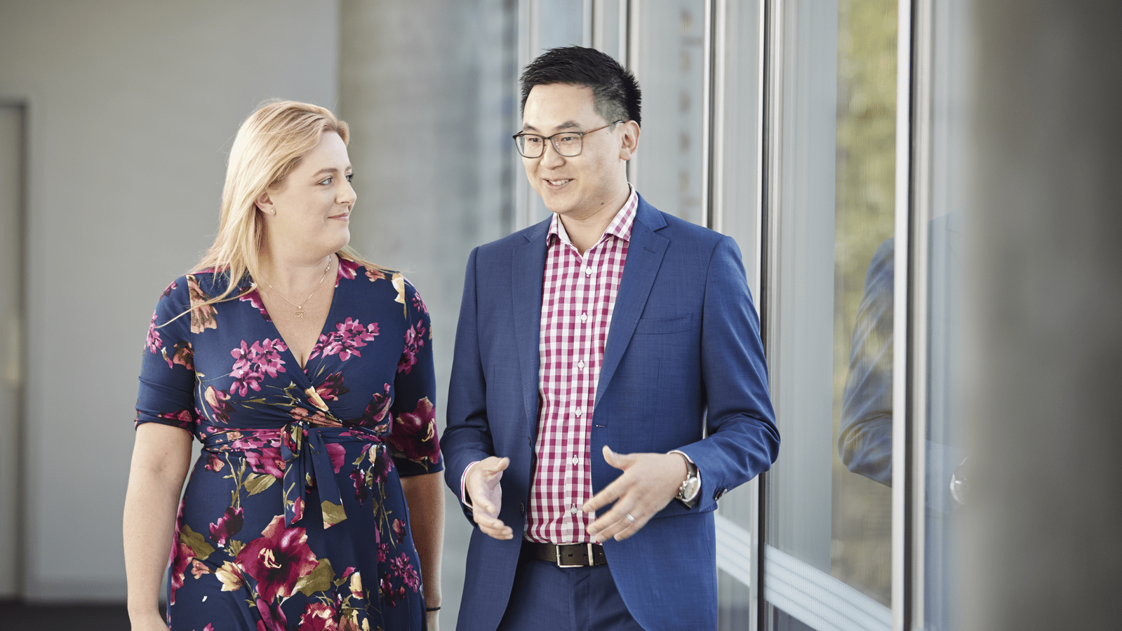 Man and Woman walking and talking in office hallway