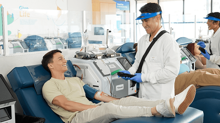 Photo of a male plasma donor and a male employee at a CSL Plasma Center