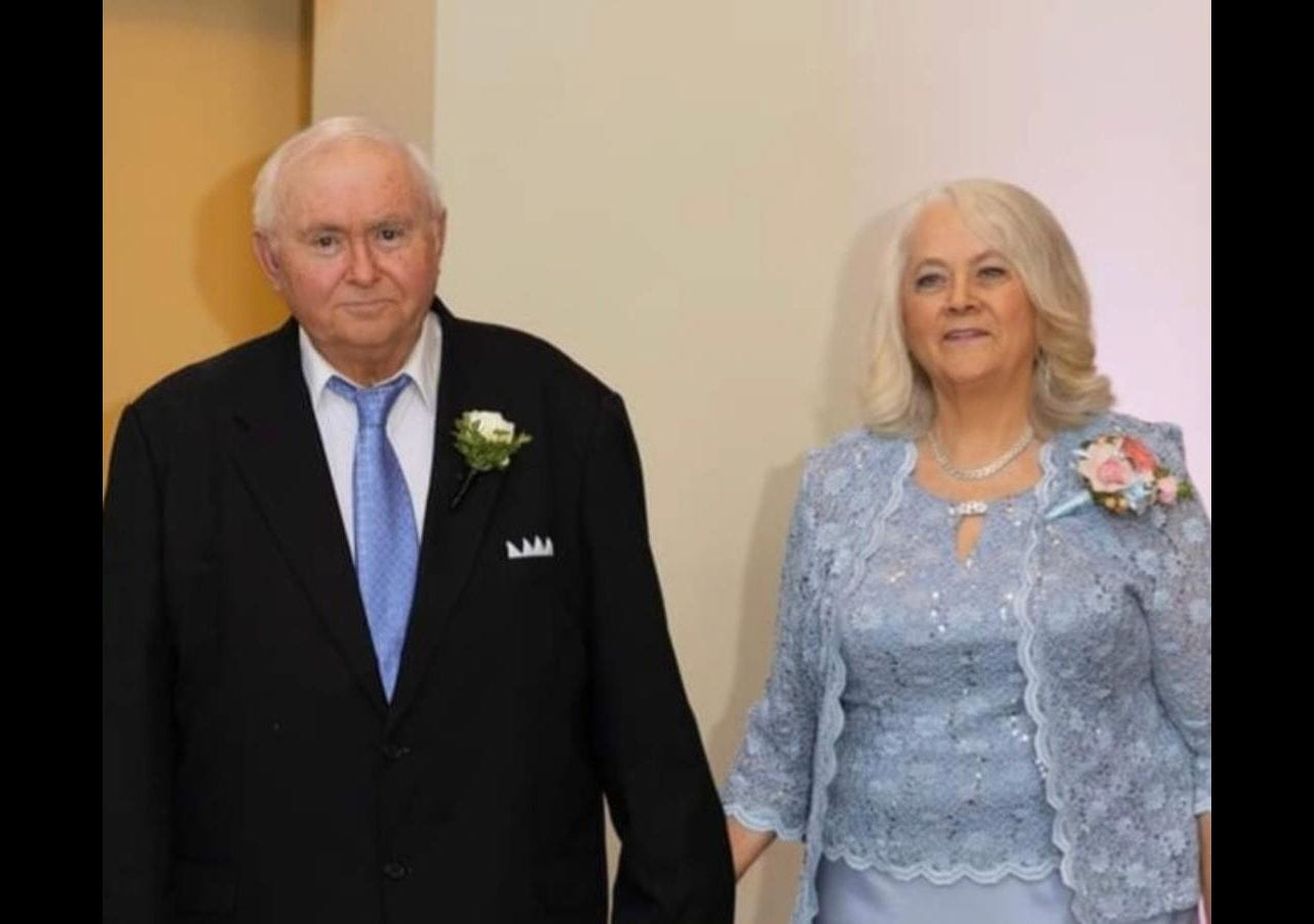 Ronald and Margaret-Mary Shellito holding hands at a formal event.