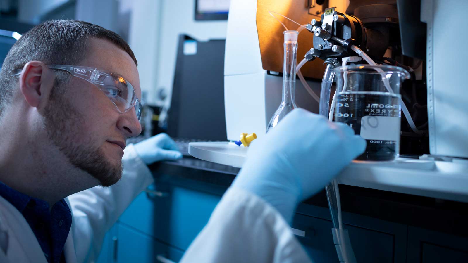 Man examining beaker