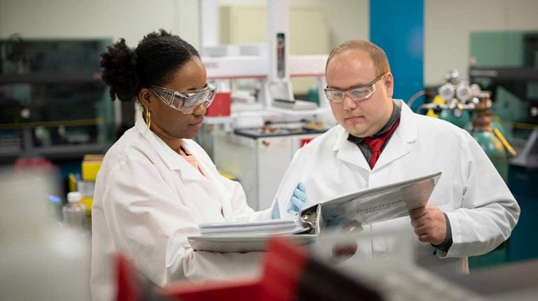 Technicians looking at binder