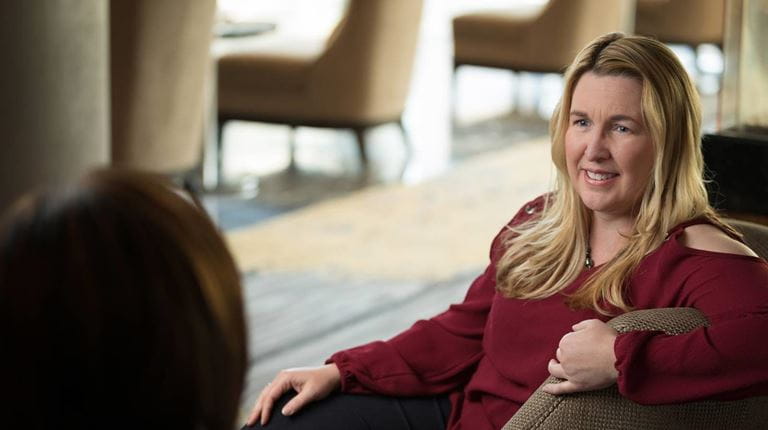 PI patient Lori sitting on a couch