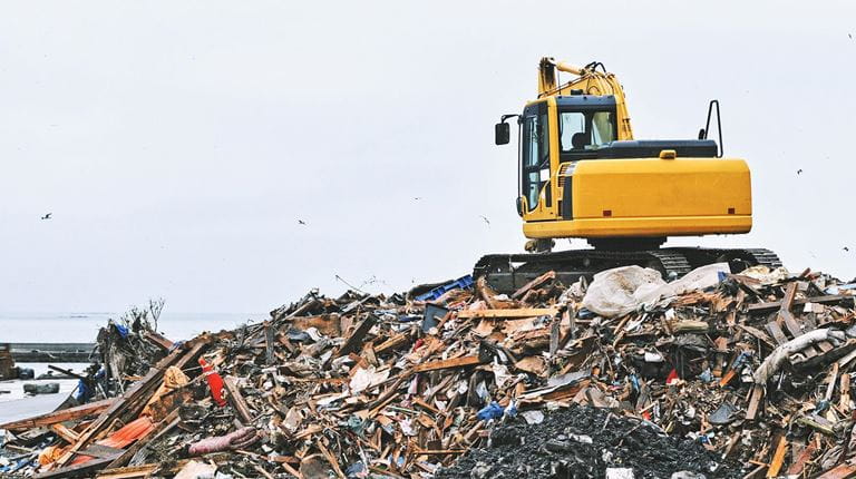 Digger sitting on land waste