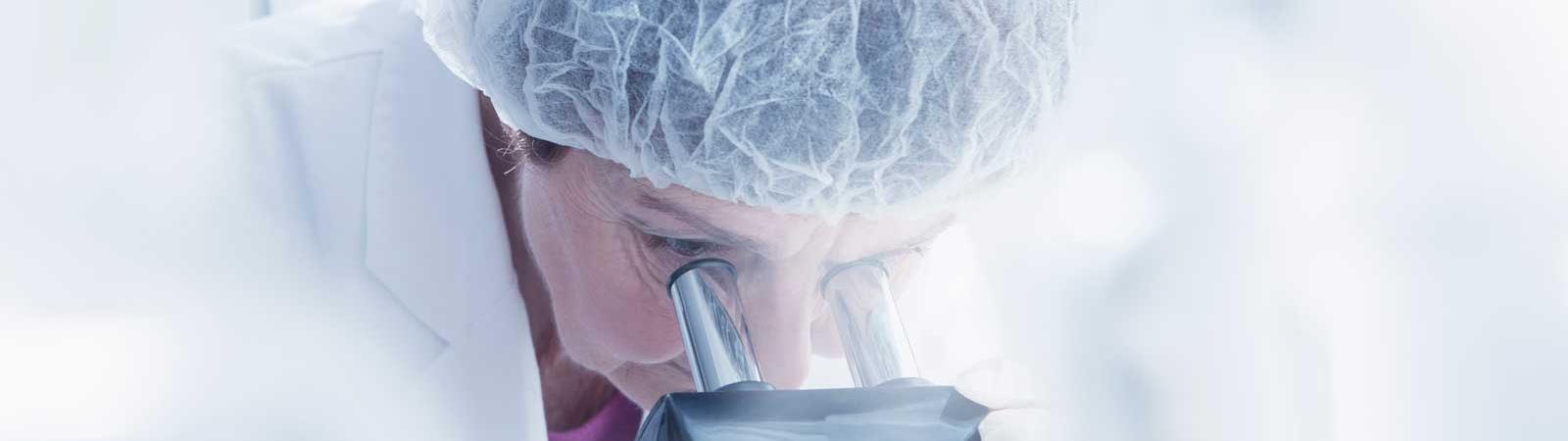Female scientist looking into microscope