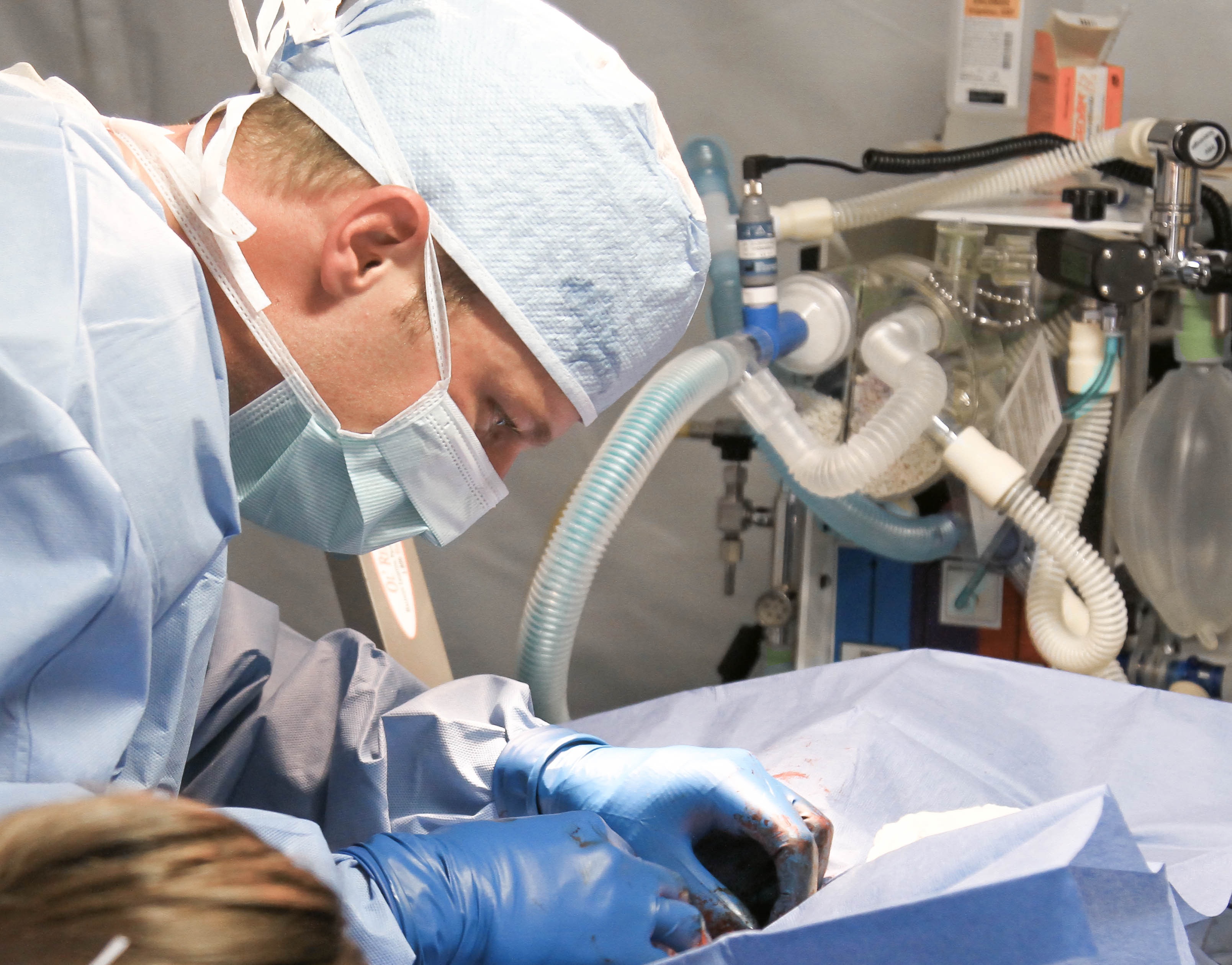 picture of a gowned doctor in operating theatre operating on a person