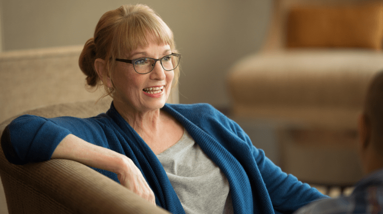 Image of a woman sitting on a couch and smiling