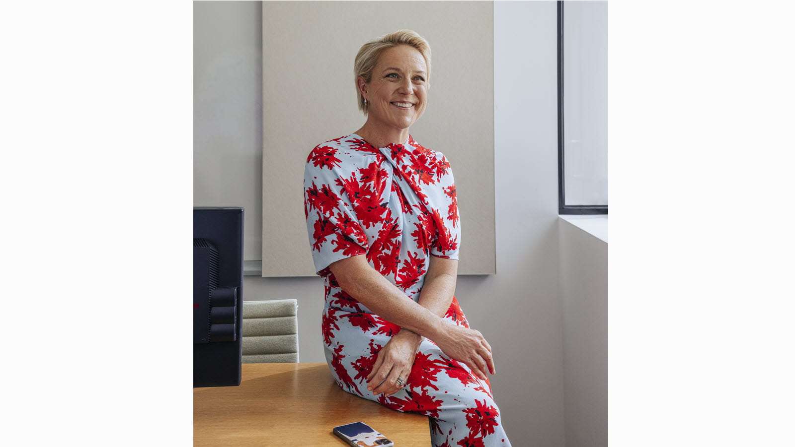 CSL's Bev Menner seated in a floral dress with arms crossed at wrists