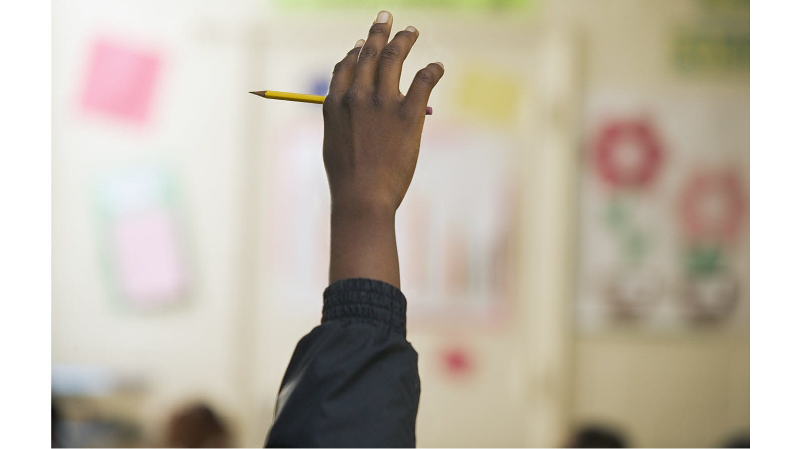 child's hand being raised in class
