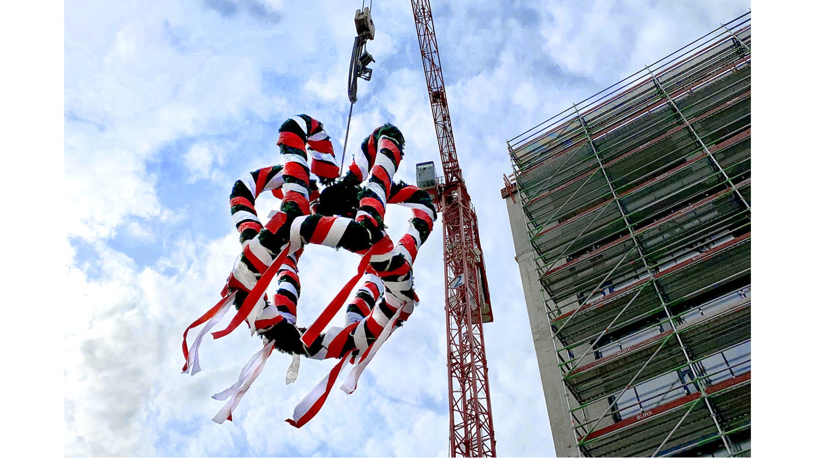 Lifting a wreath of multicolored ribbons to celebrate the topping out of a building in Marburg, Germany