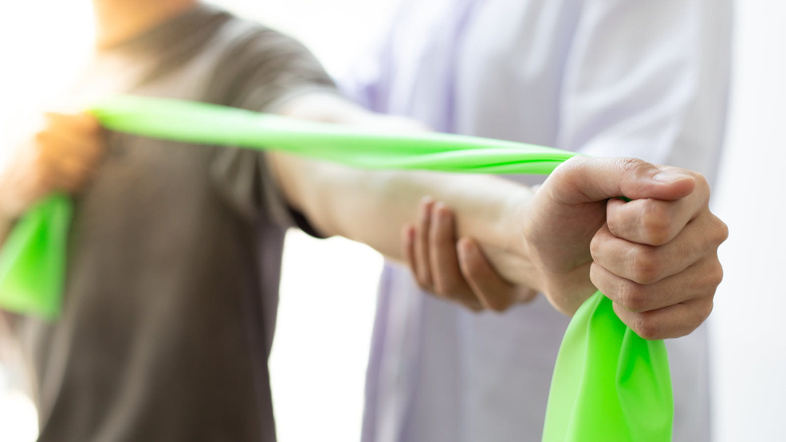 Patient gets help using a green resistance band