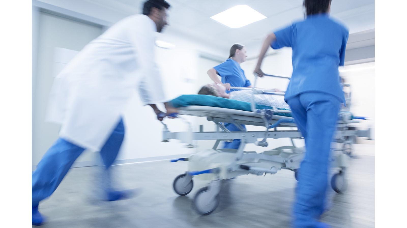 Hospital trauma team speeds a stretcher through a hospital hallway