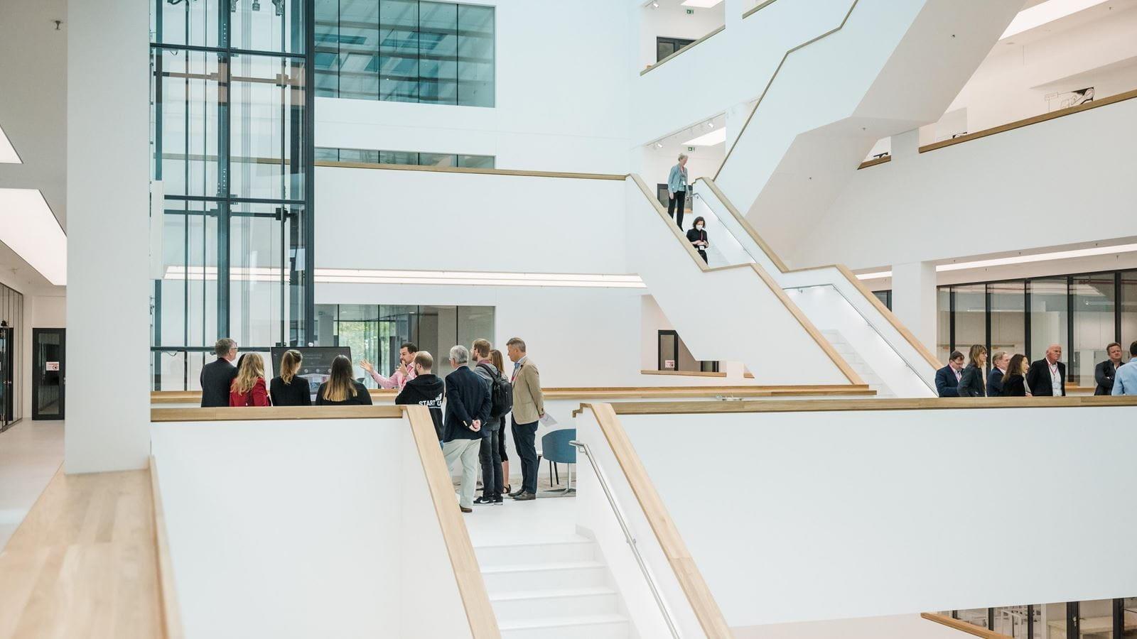 A crowd stands on the landing of the M600 R&D building staircase during the launch event.