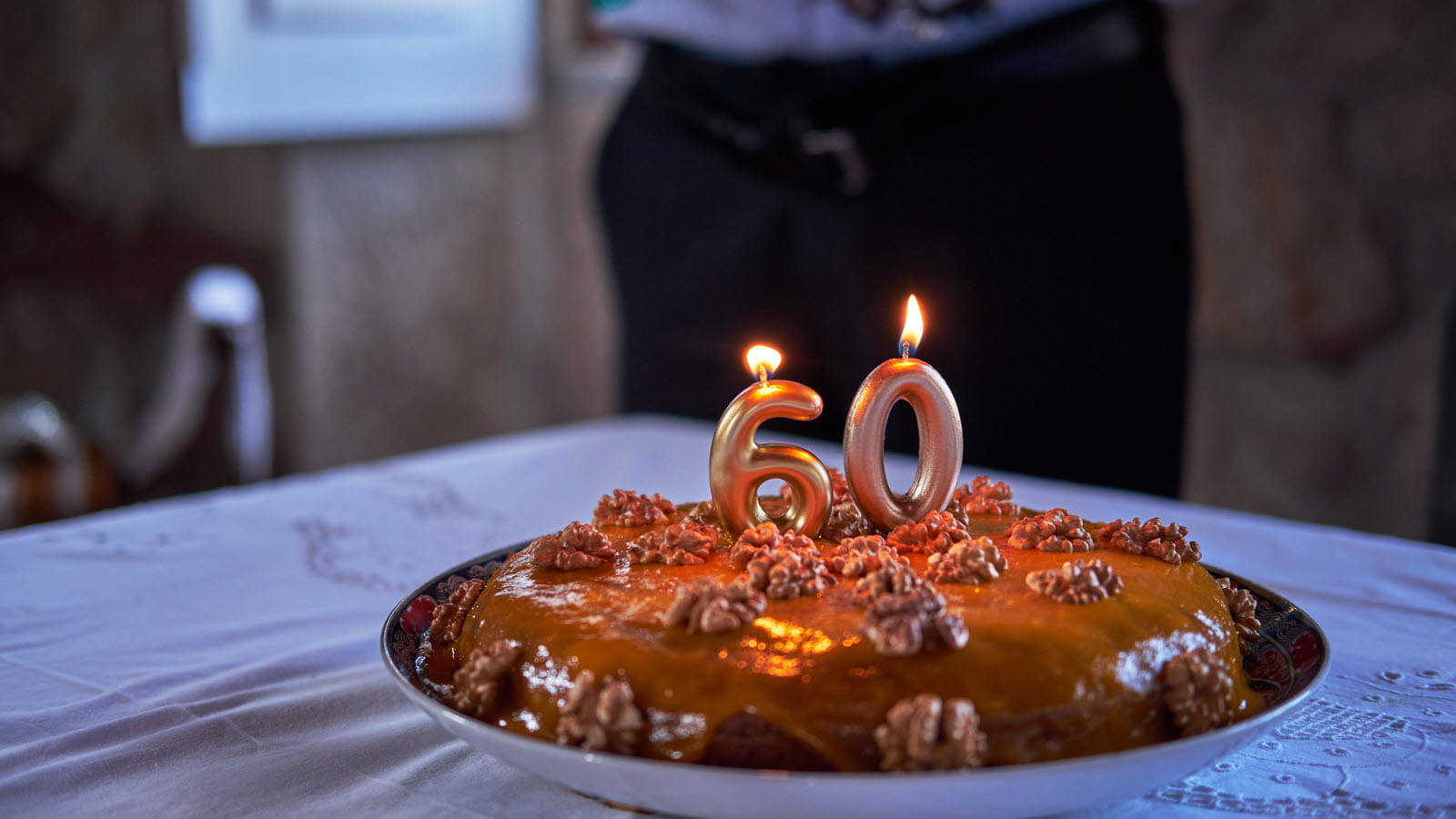 chocolate cake for a 60th birthday with a numeral 6 and 0 candles