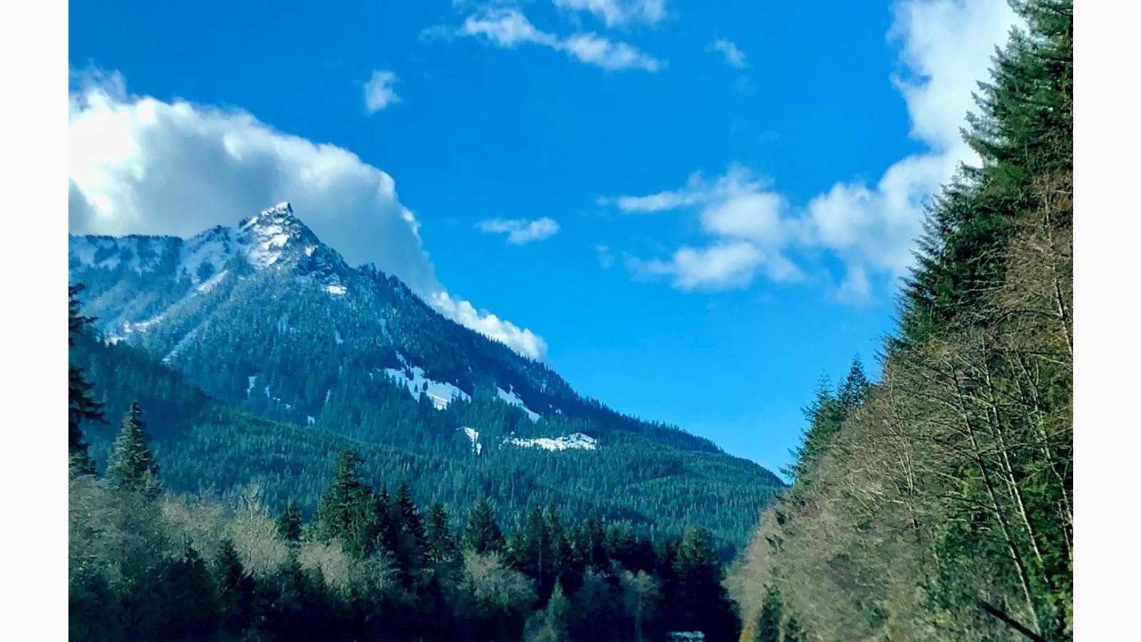 Snoqualmie Pass in Washington state, USA - snow-capped mountain range against a blue sky with puffy white clouds