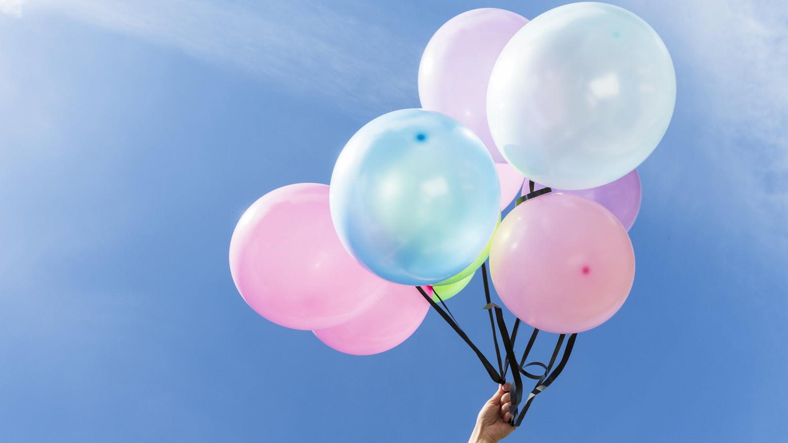 pink and blue balloons against a blue sky