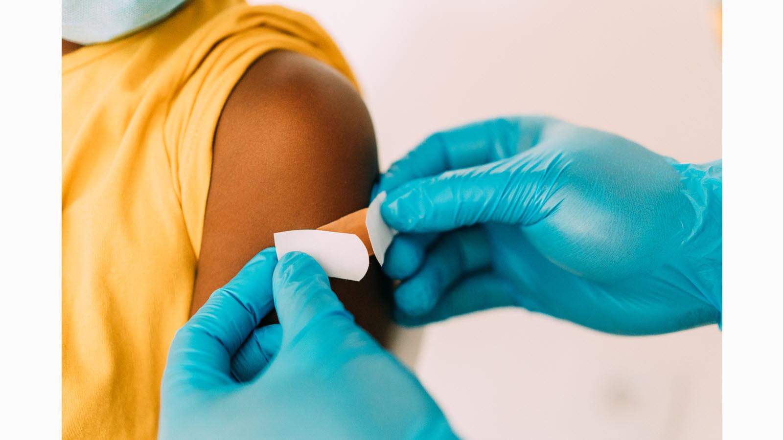 Nurse applies a bandage after a vaccination