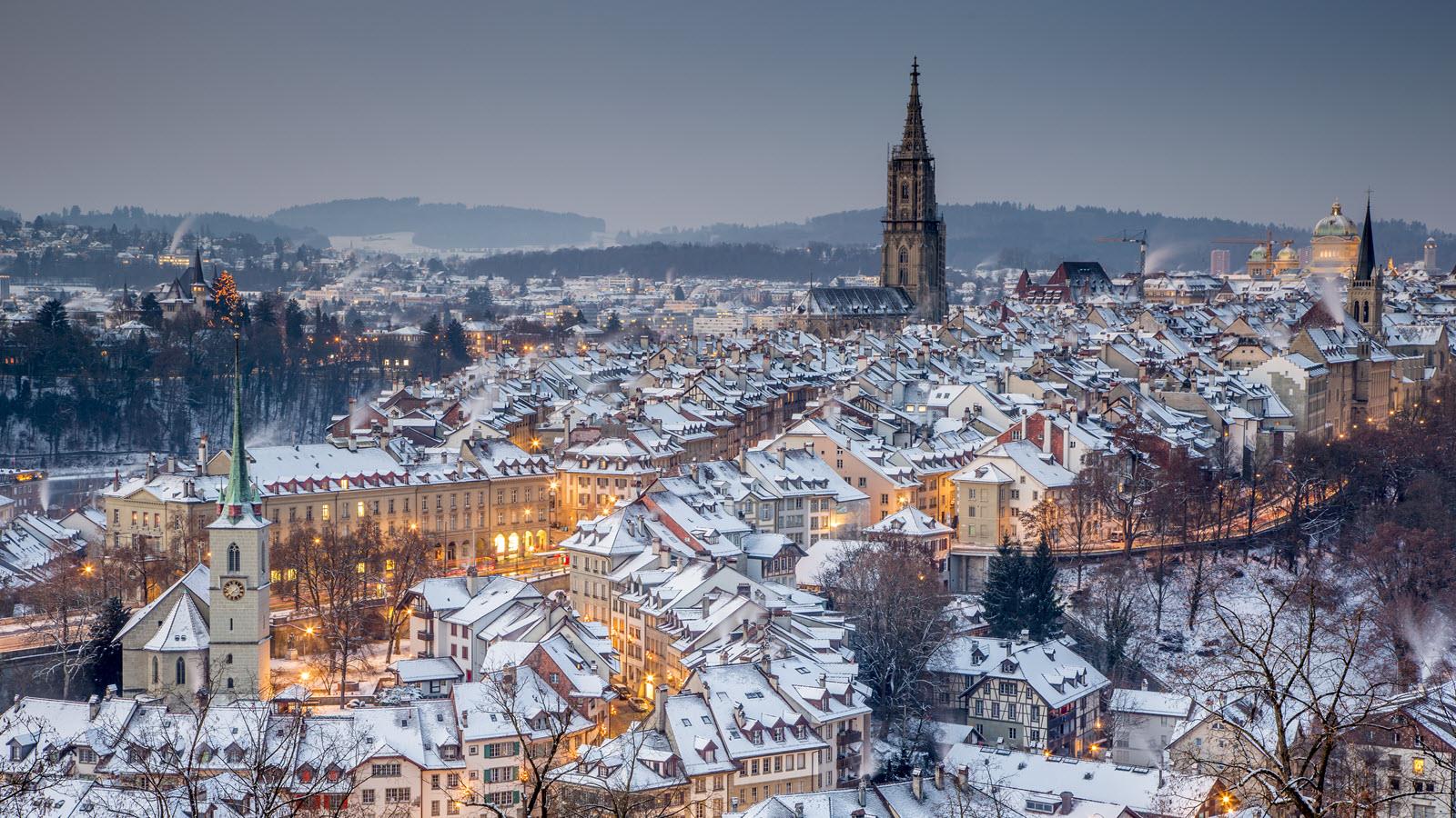 The snow-dusted Swiss capital city of Bern with the tower of its cathedral against the horizon