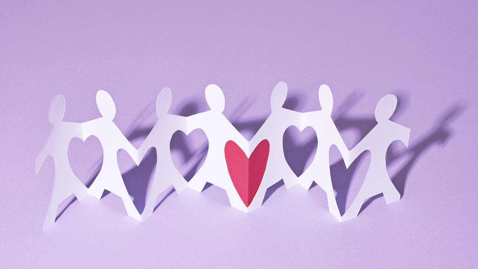 connected paper dolls with a heart between them to illustrate kidney transplant chains