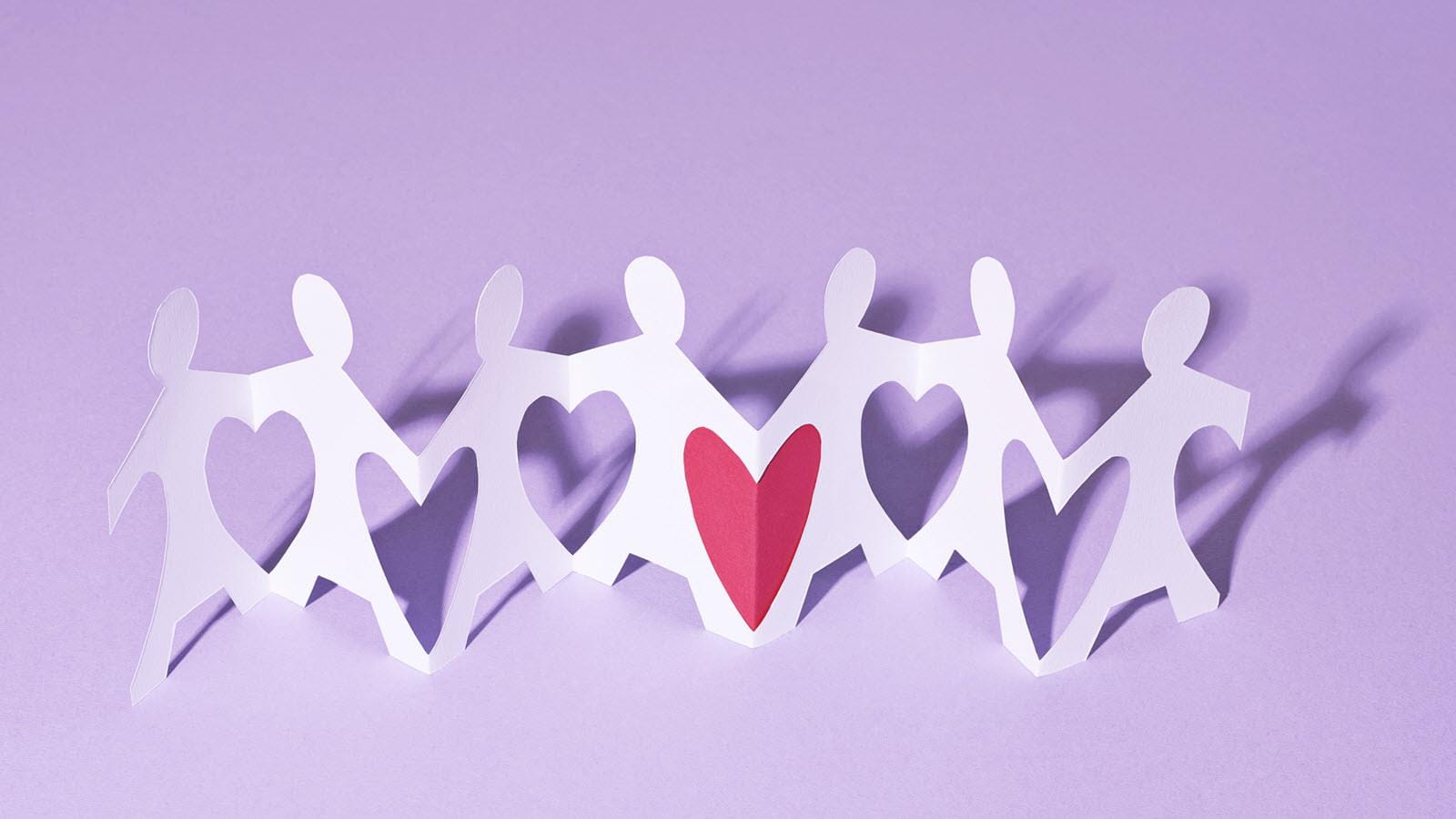 connected paper dolls with a heart between them to illustrate kidney transplant chains