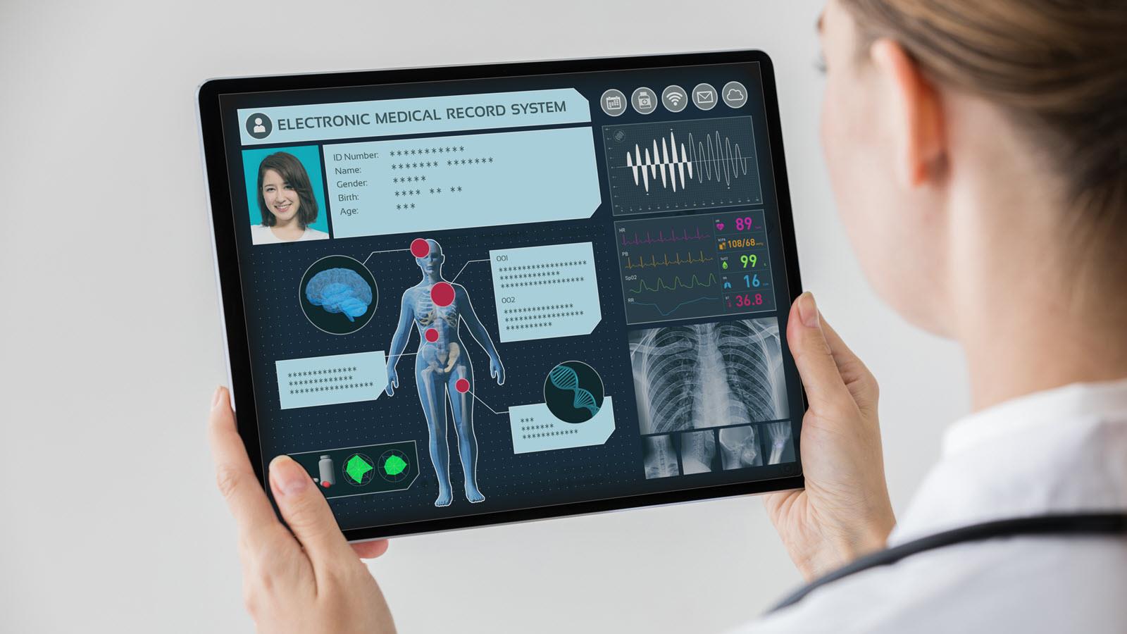 Nurse looks at an electronic medical record on a tablet device
