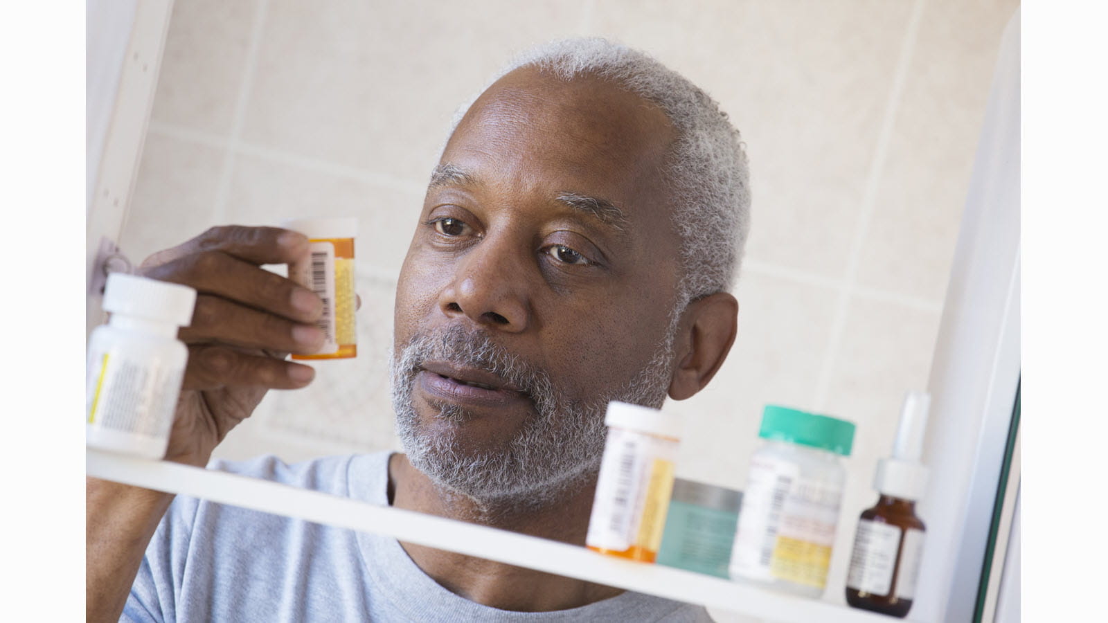 Man looking into medicine cabinet