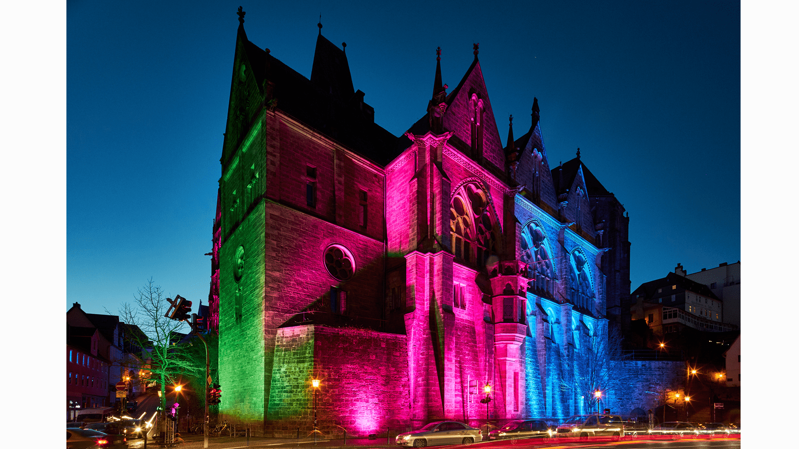 Historic University in Marburg, Germany, lit up in the green, purple, pink and blue colors of Rare Disease Day.