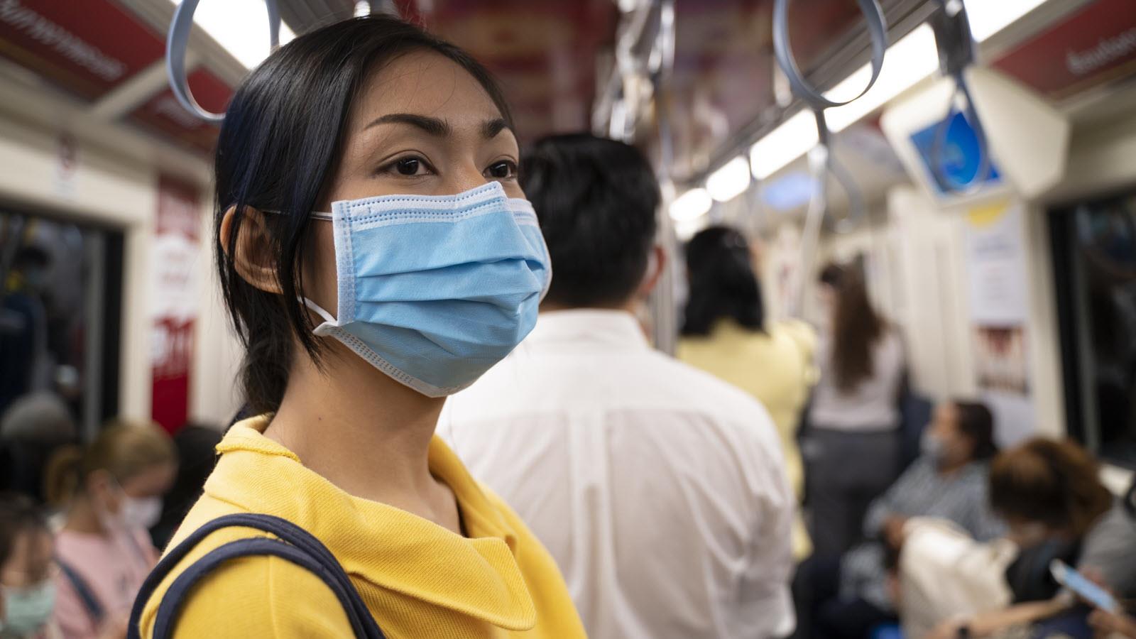 masked woman on subway