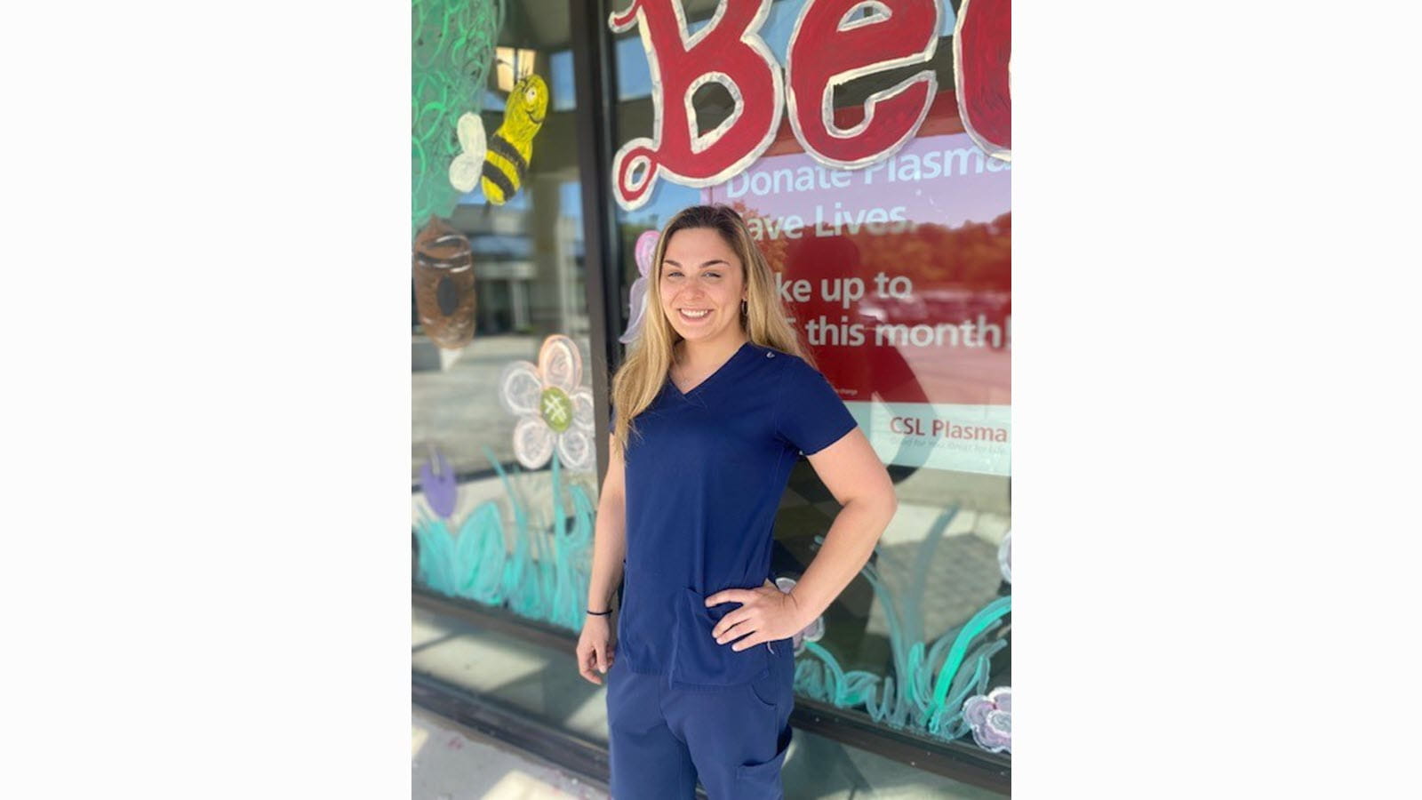 CSL Plasma employee Morgan Wood with one hand on her hip outside a plasma collection center