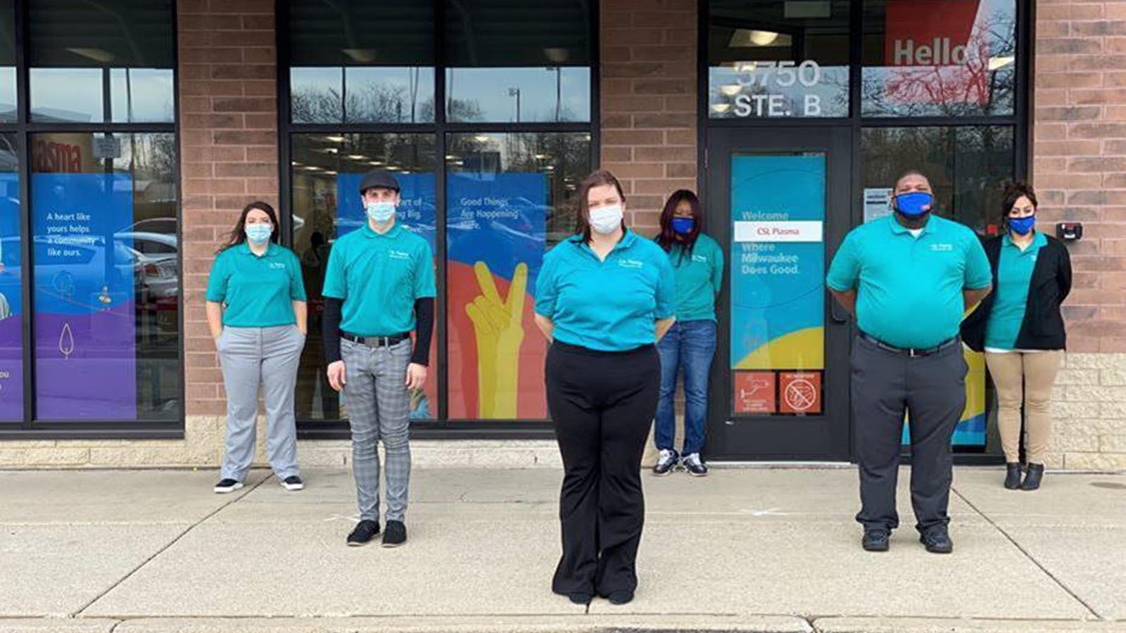 Sarah Sweat and team in teal shirts outside of CSL Plasma in Milwaukee.