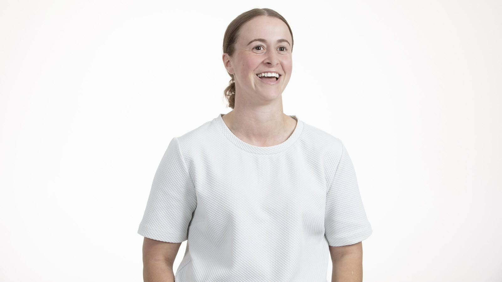 photograph of a smiling Simone Ruedin, who is a Seqirus vaccine production coordinator, in a white shirt on a white background