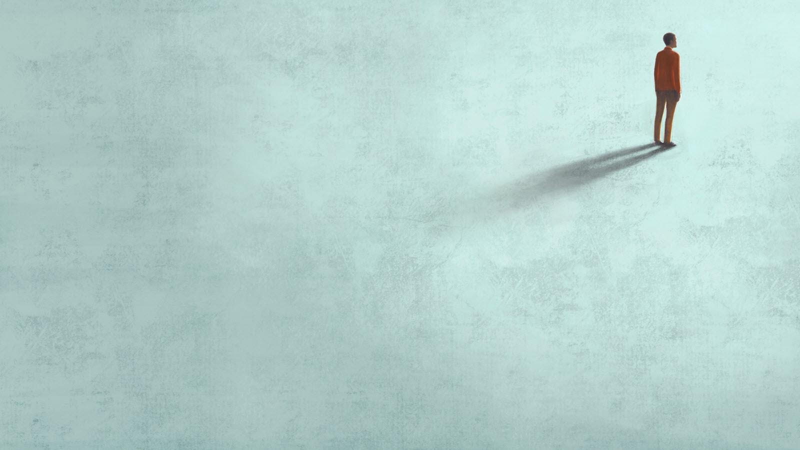 Person standing alone in the upper right corner of an empty space