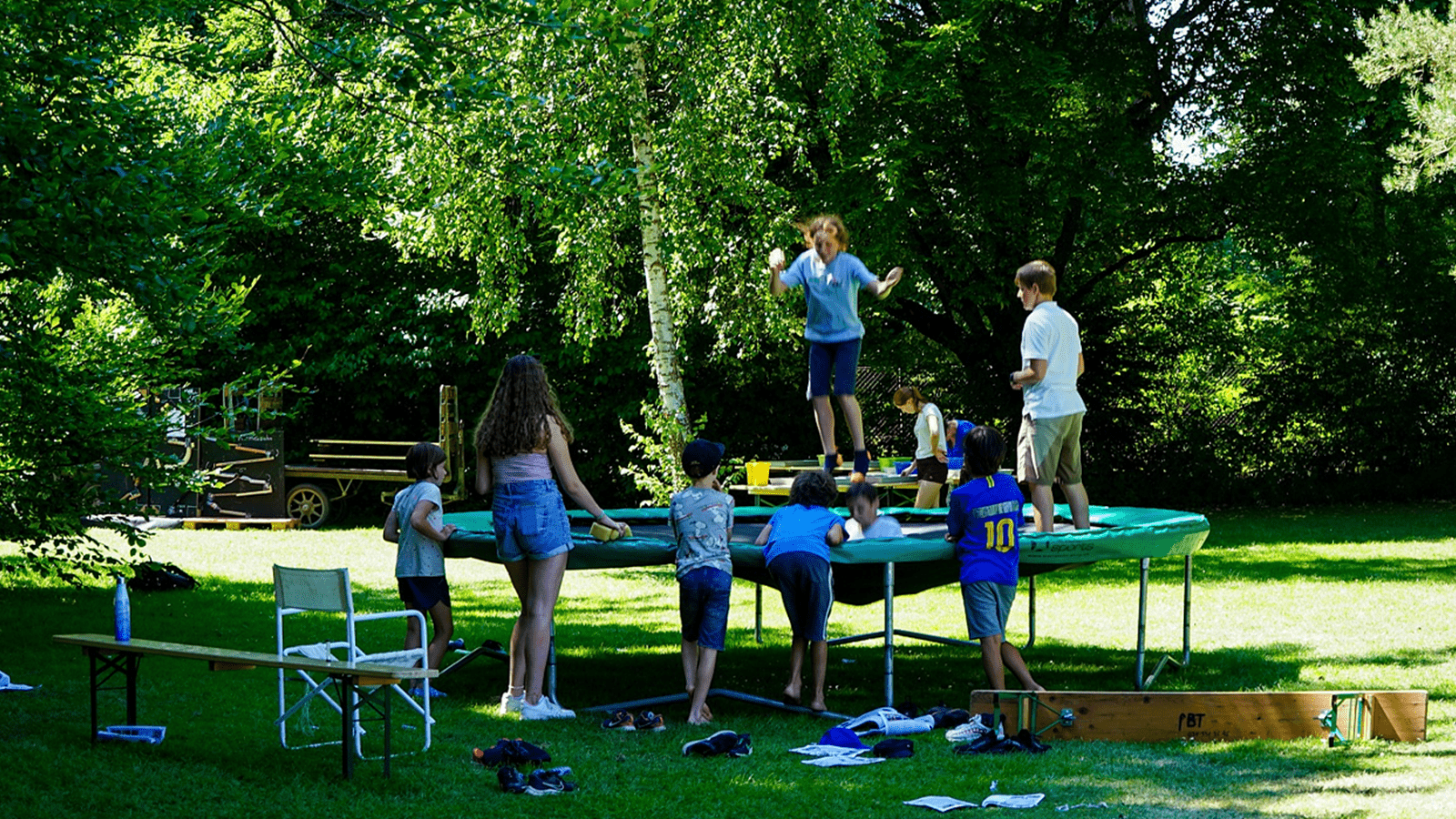 Summer campers jump on a trampoline.