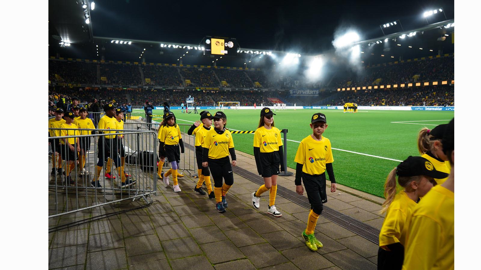 Children enter Wankdorf Stadium.