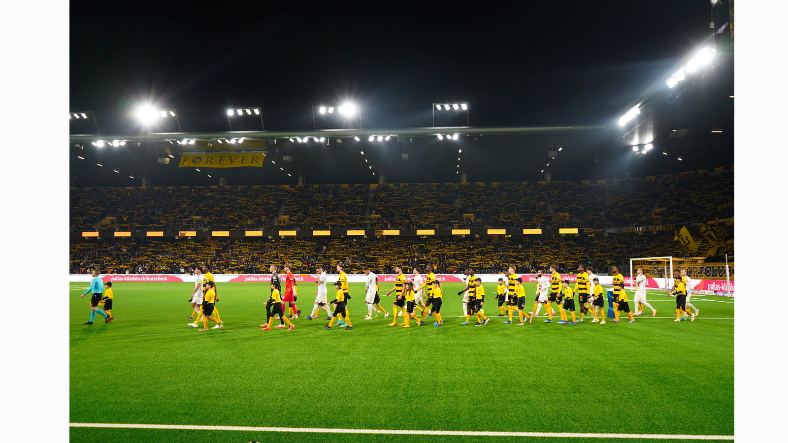 Children of CSL Behring employees walk onto the pitch at Wankdorf Stadium.