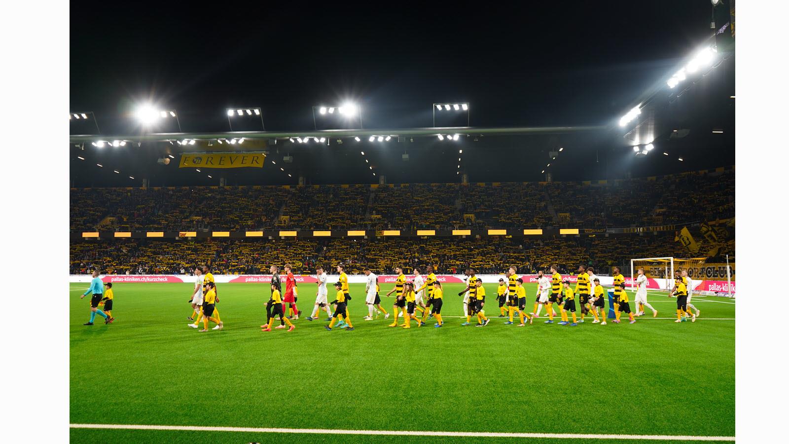 Children of CSL Behring employees walk onto the pitch at Wankdorf Stadium.