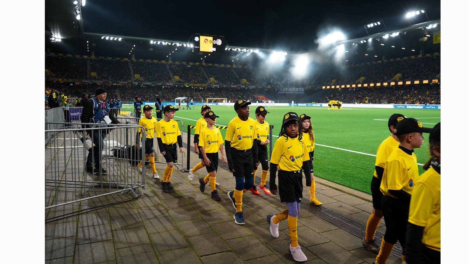 Children enter Wankdorf Stadium.