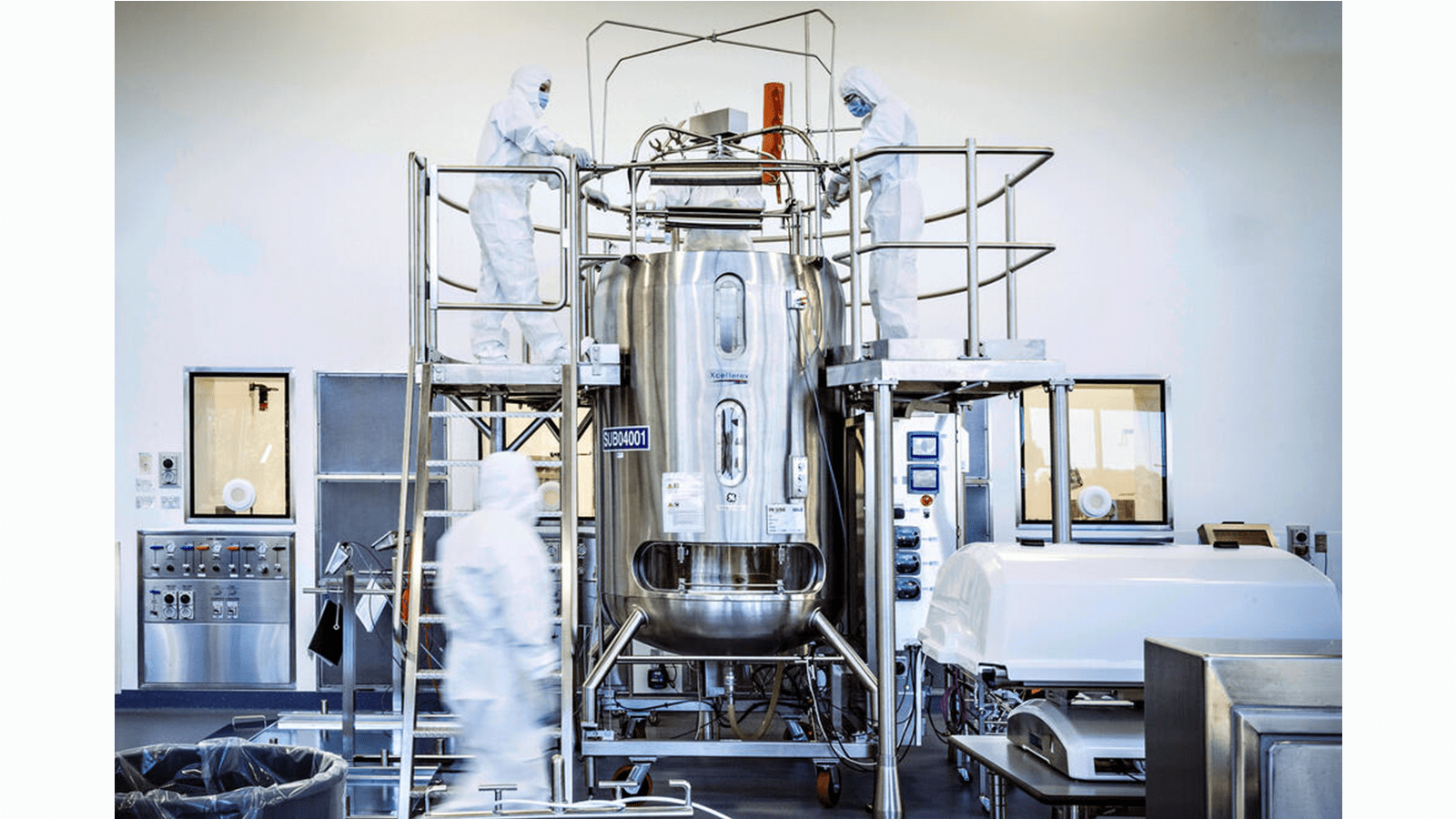 Two scientists in white protective gear work in CSL vaccine manufacturing during the COVID-19 pandemic