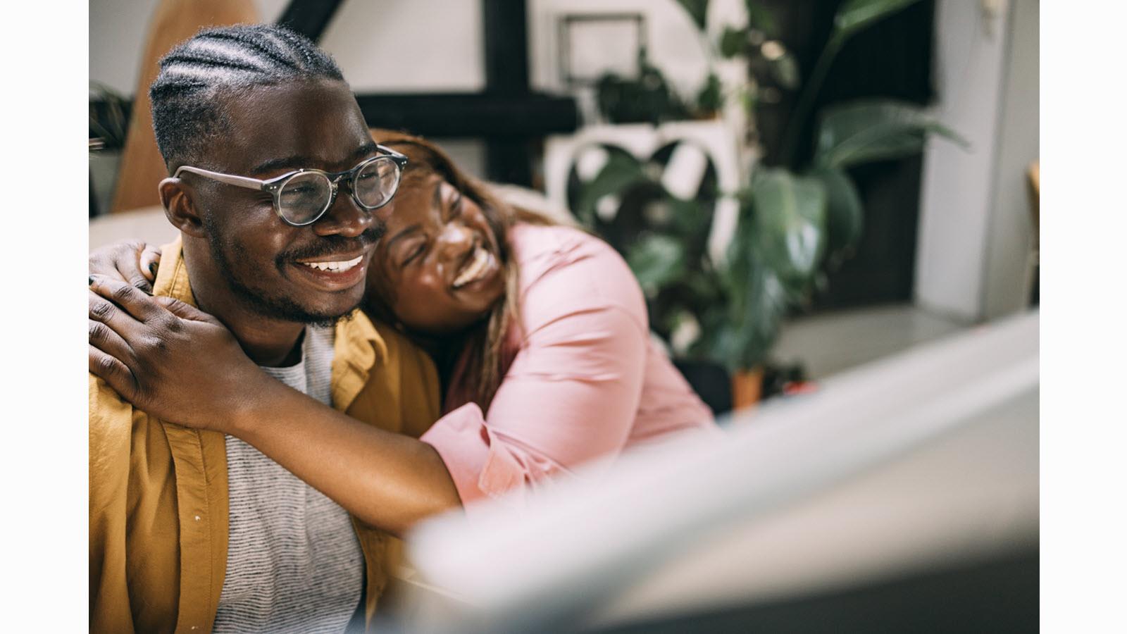 A happy couple - a woman rests her head on her partner's shoulder